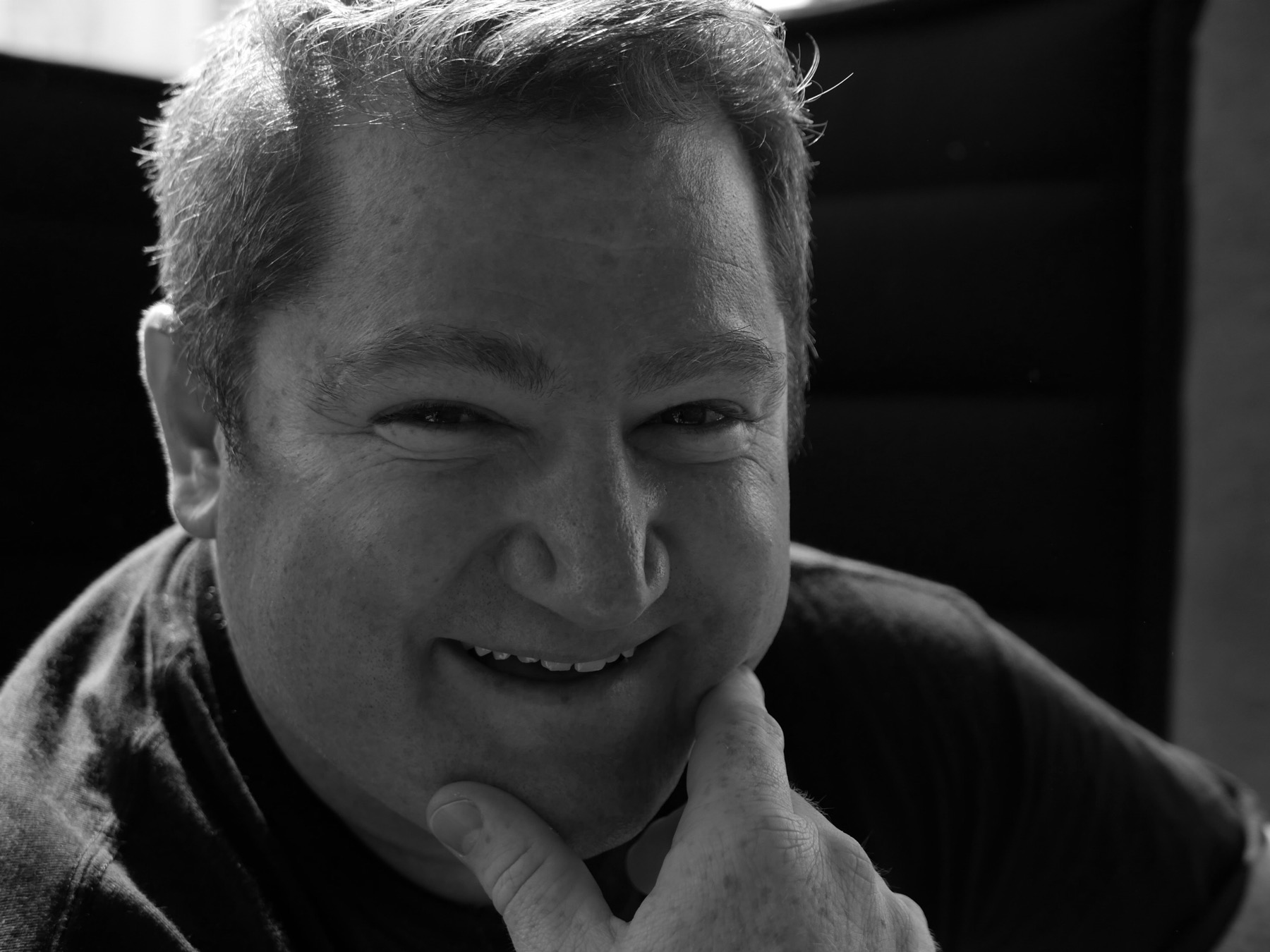 Alex Learmonth smiling in a black and white portrait
